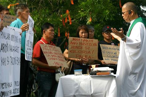 Father Robert Reyes leads the rally against a court order allowing Arroyo to travel.  Nov. 16, 2011